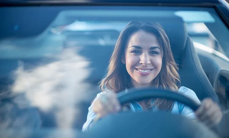Happy driver behind the wheel with a clear windshield